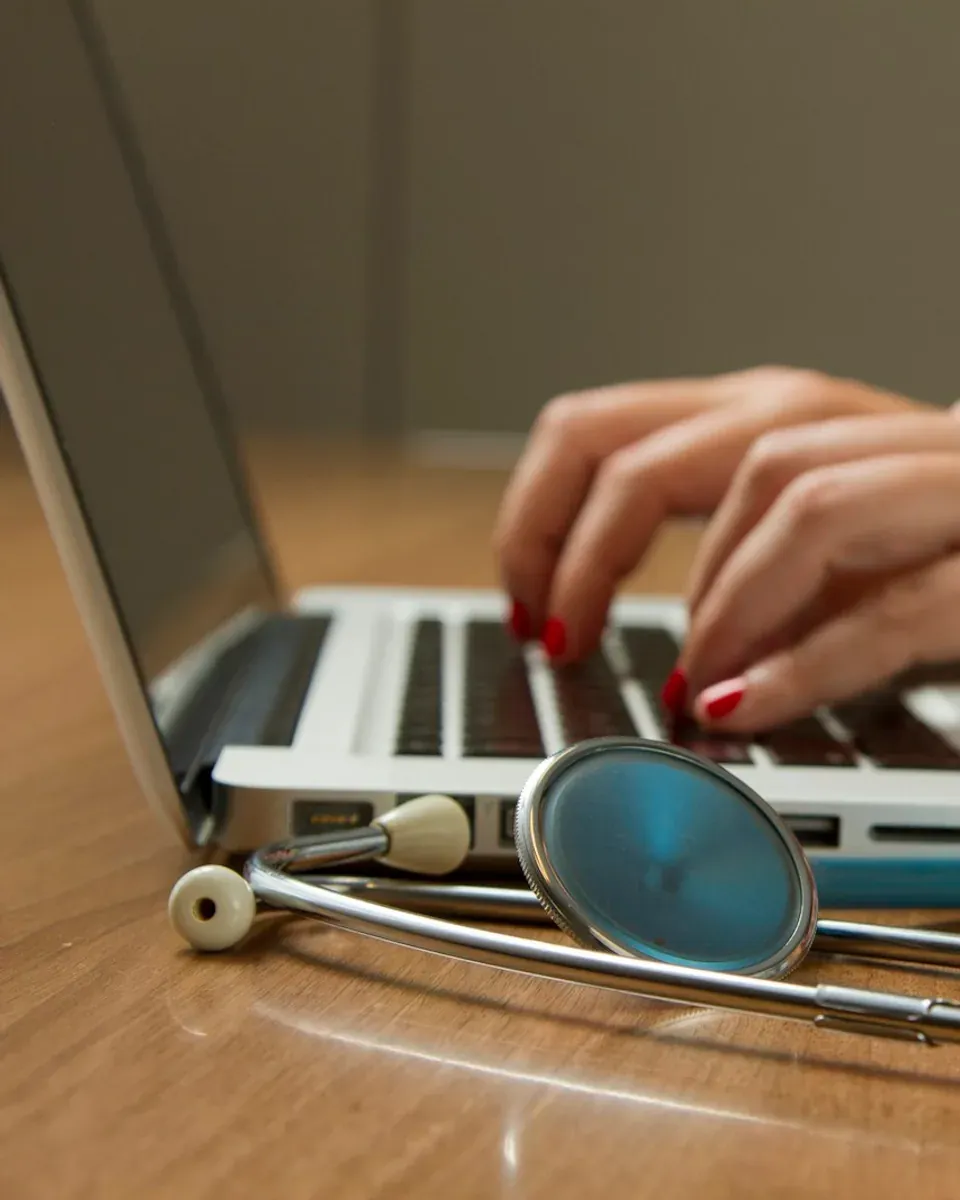 Profissional usando um computador ao lado de um estetoscópio